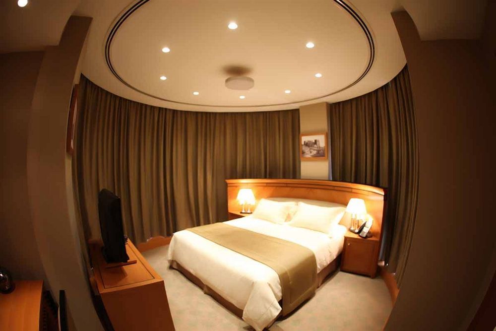 Wiseman Grand Hotel Doha Eksteriør billede A bedroom in a hotel